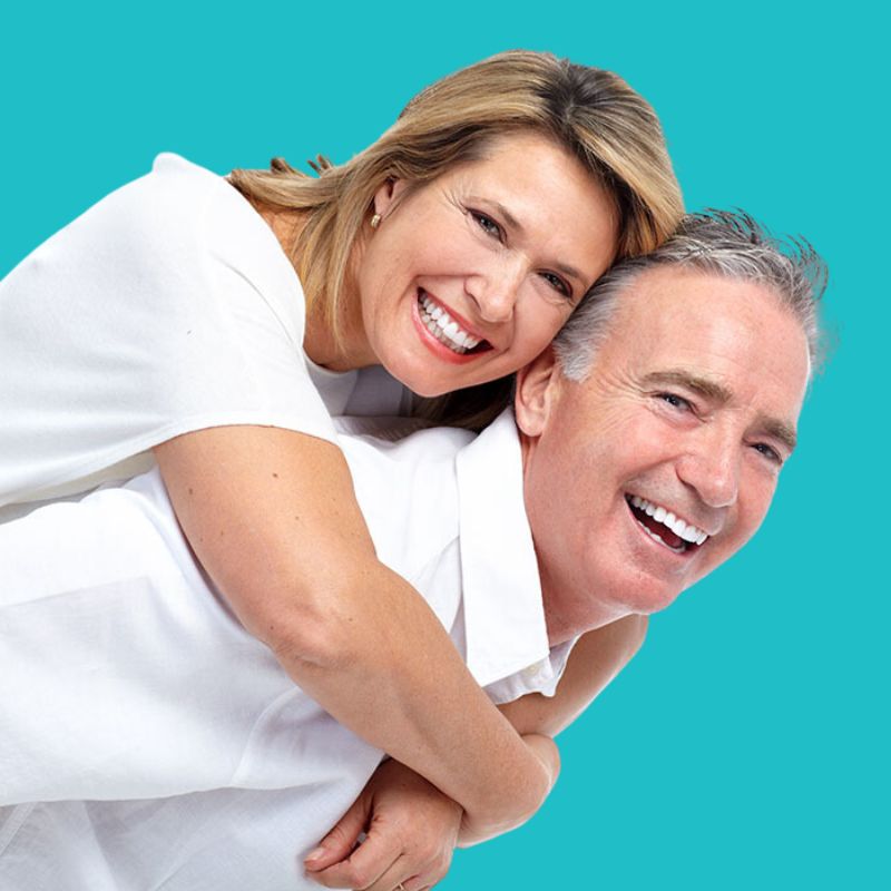 Happy middle aged man and woman smiling with their teeth wide open after a very successful Oral Surgery from Implants Network in Toronto